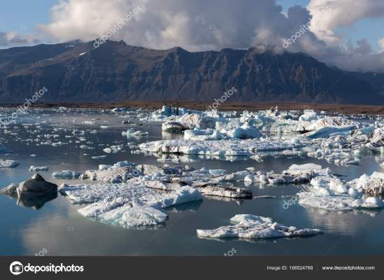 Scattered melting icebergs in Jokulsarlon glacier lagoon. Base of the Vatnajokull glacier at Jokulsarlon, Iceland.